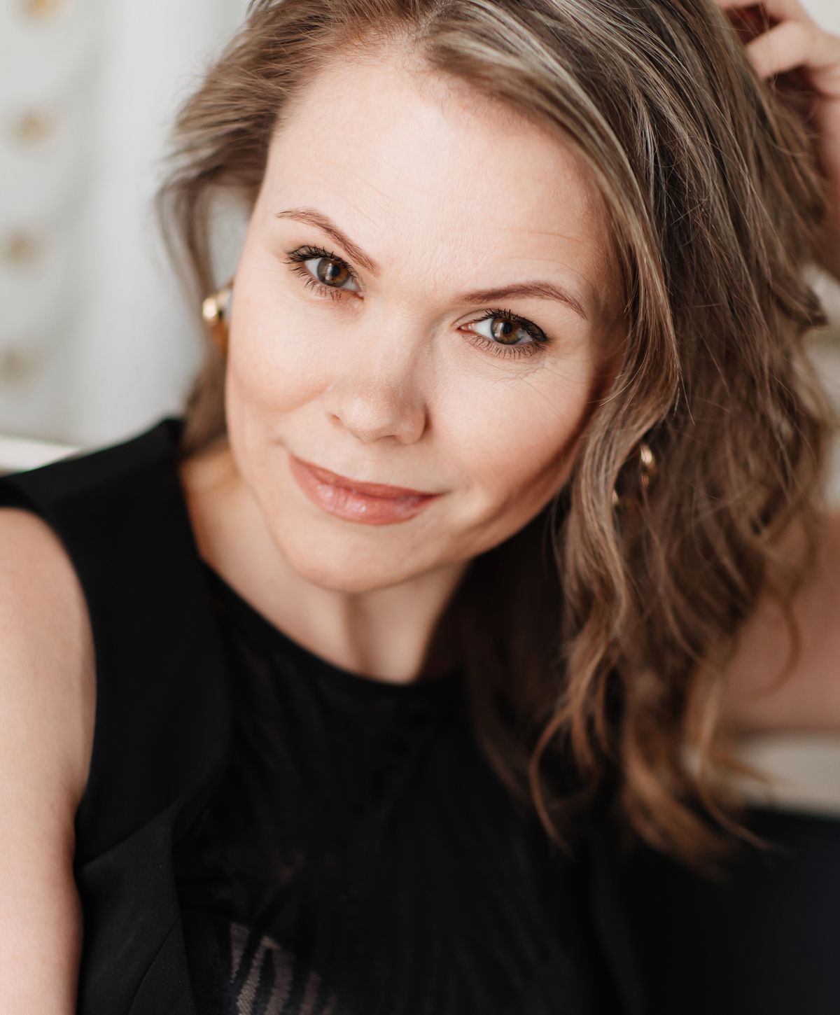 Woman with wavy hair and warm expression.