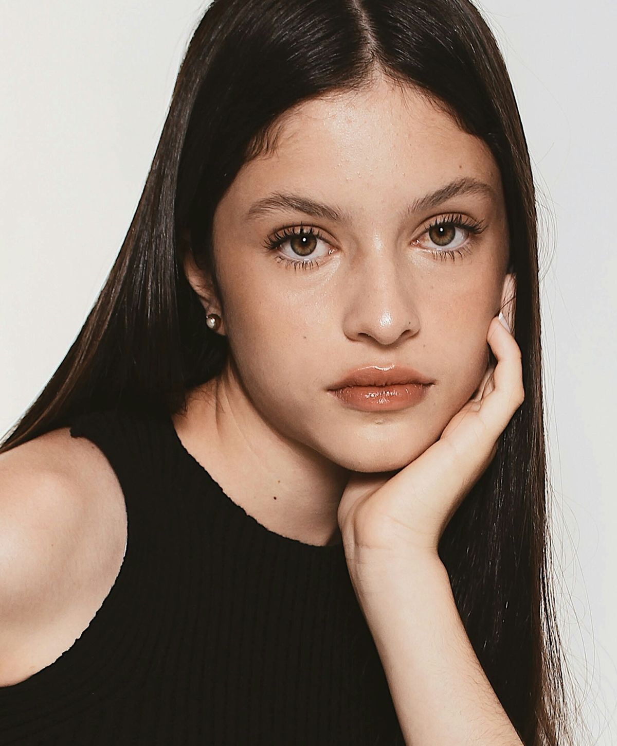 Young woman with long hair, thoughtful expression.