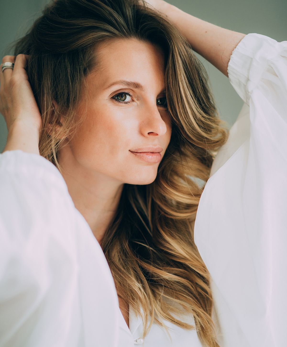 Woman with long hair, wearing a white blouse.