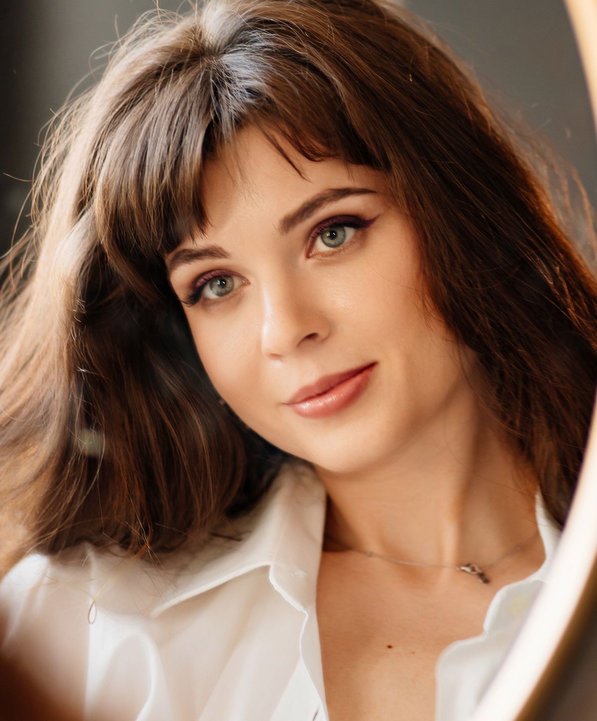 Woman with long hair and natural makeup.