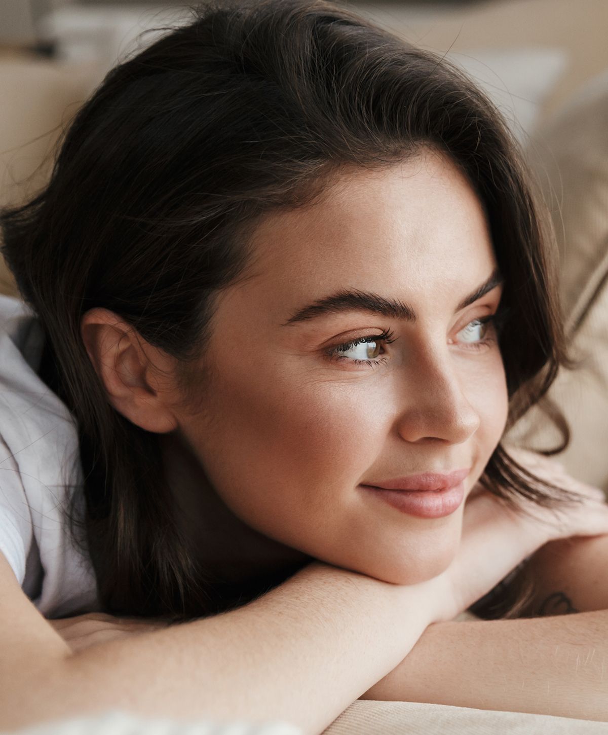 Smiling woman resting her chin on hands.