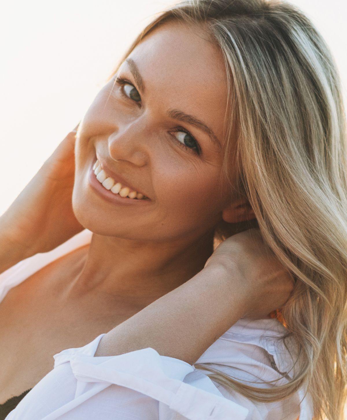 Smiling woman with blonde hair, outdoors.