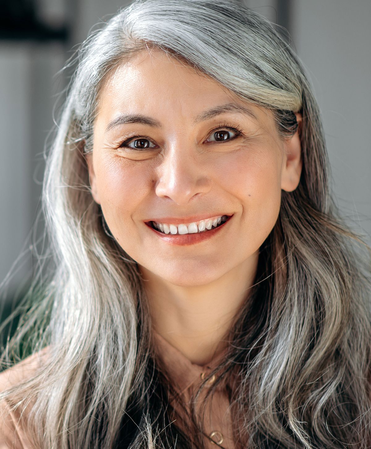 Smiling woman with long, silver hair.
