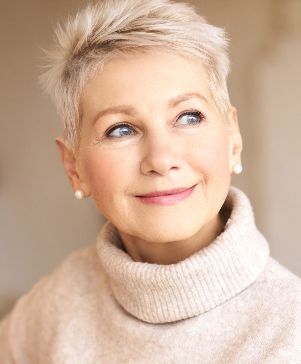 Smiling woman with short hair and turtleneck sweater.