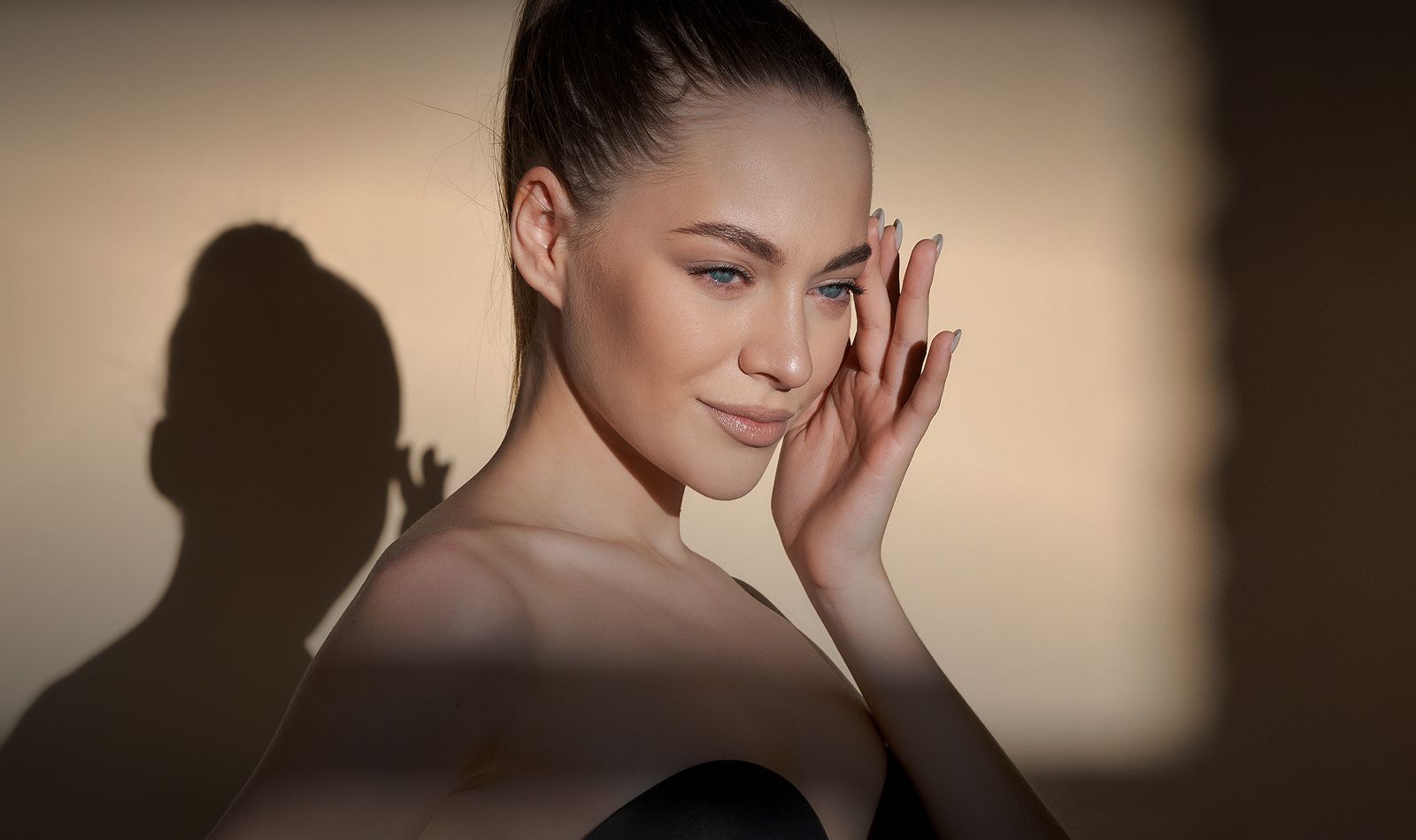 Woman touching her face with stylish lighting.